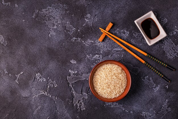 Rice in a bowl and wooden chopsticks.