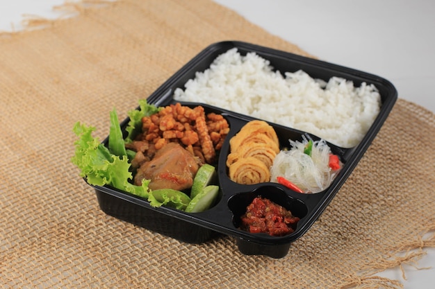 Rice Box or Indonesian Nasi Kotak with Soy Sauce Chicken, Oreg Tempeh, and Spicy Paste