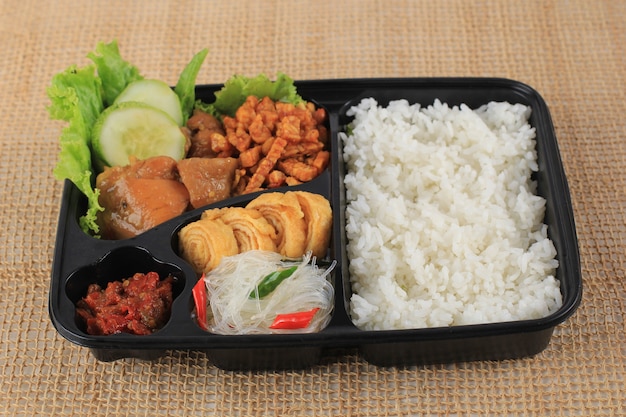 Rice Box or Indonesian Nasi Kotak with Soy Sauce Chicken, Oreg Tempeh, and Spicy Paste