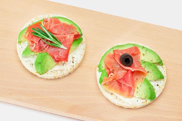 Photo rice cake sandwich with avocado jamon olives and rosemary