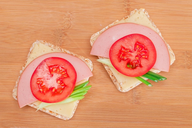 Rice cake sandwich with tomato sausage green onions and cheese