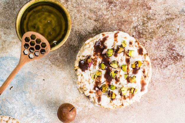 Rice cake with honey and nuts. Healthy breakfast. Macadamia nuts with honey. Vegetarian breakfast. Sweet breakfast top view. Rice dessert. Healthy christmas dessert,