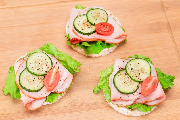 Photo rice cakes with ham tomato fresh cucumber and green salad