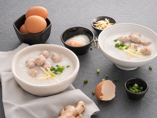 Rice congee with minced pork in white bowl. Bowl of rice porridge with soft boiled egg. Asian breakfast