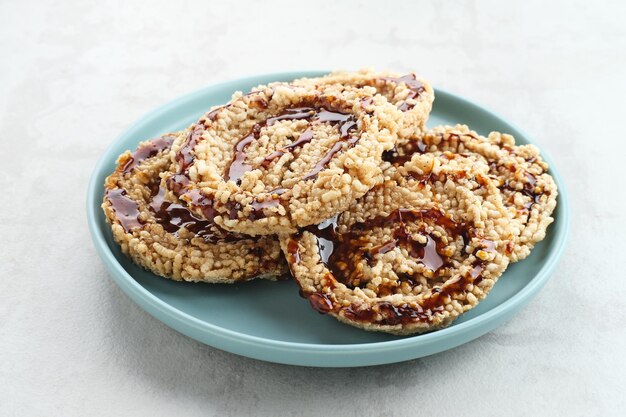 Rice crackers intip madu or rengginang with brown sugar on white background Savory and sweet