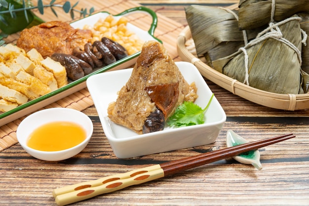 Rice dumpling is a traditional Chinese rice dish made of glutinous rice and wrapped in bamboo leaves Dragon Boat Festival is making and eating zongzi with family