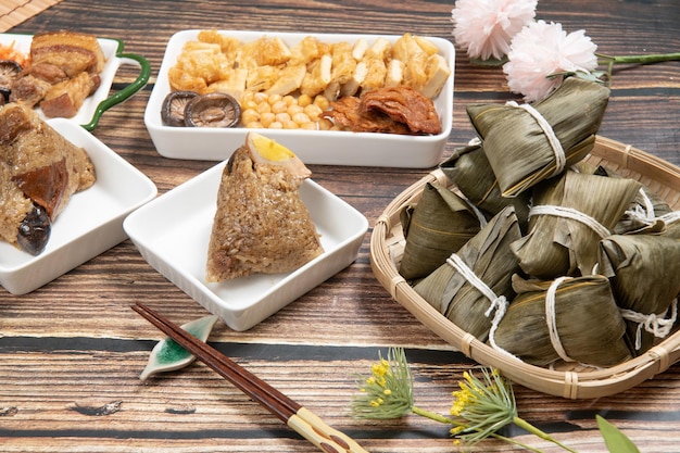 Gli gnocchi di riso sono un piatto di riso tradizionale cinese a base di riso glutinoso e avvolto in foglie di bambù il dragon boat festival sta preparando e mangiando zongzi con la famiglia
