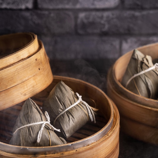 Rice dumpling zongzi chinese rice dumpling zongzi on black\
brick background slate table concept of dragon boat festival\
traditional food close up