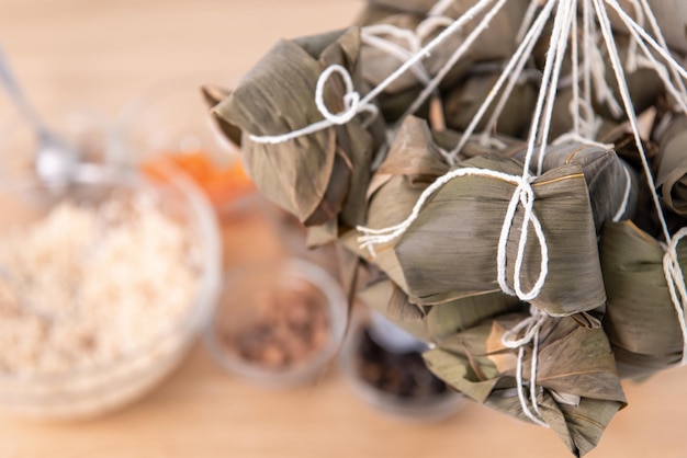 Rice dumpling zongzi making wrapping chinese rice dumpling
zongzi on table at home for dragon boat festival celebration close
up lifestyle