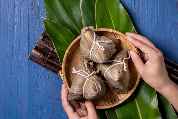 Rice dumpling zongzi Traditional Chinese food on blue wooden background of Dragon Boat Festival Duanwu Festival top view flat lay design concept