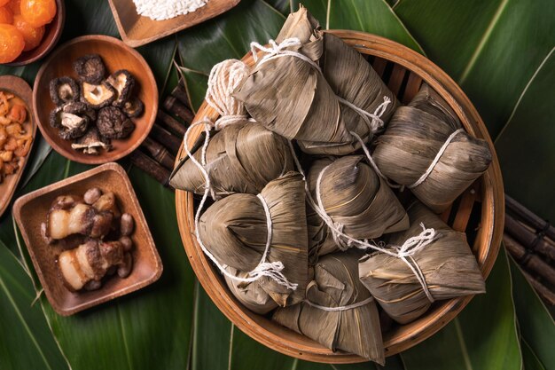 드래곤 보트 축제 Duanwu 축제의 녹색 잎 배경에 쌀 만두 zongzi 전통 중국 음식 평면 디자인 개념