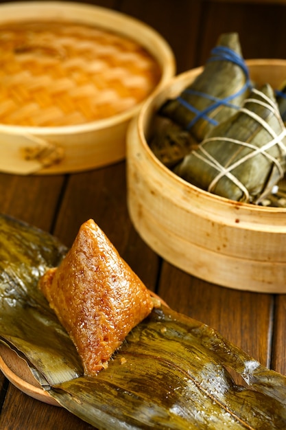 Rice dumplings zongzi and bamboo steamer on wooden table