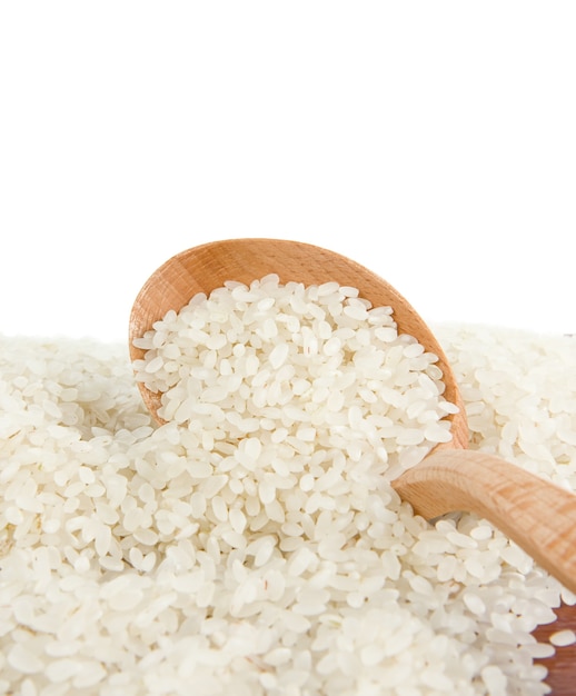 Rice grain in wooden spoon isolated on white surface