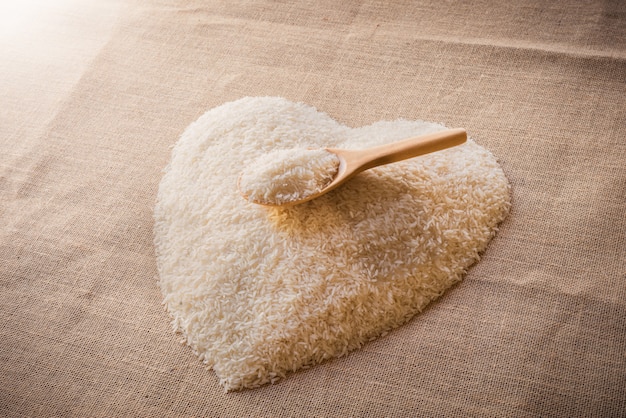 Rice laid out in a heart shape on sackcloth with wooden spoon