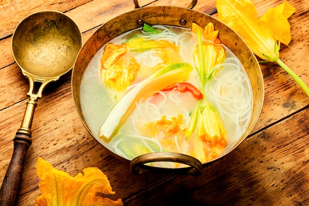 Foto zuppa di spaghetti di riso con fiori di zucca