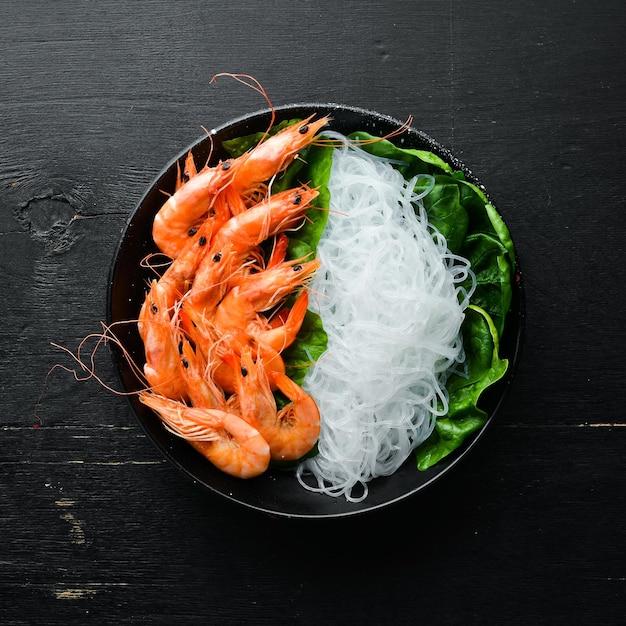 Rice pasta with shrimp and spinach Asian Traditional Cuisine Top view Free space for your text