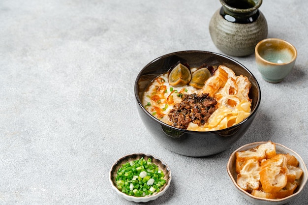 Rice porridge or congee with minced pork century egg and cakwe in bowl