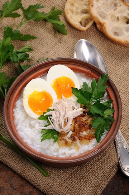 Rice porridge ginger congee with egg chicken crispy shallots and parsley