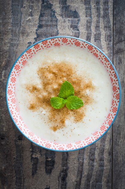 Rice pudding with cinnamon on wood