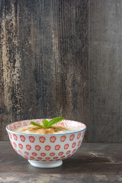 Rice pudding with cinnamon on wooden table