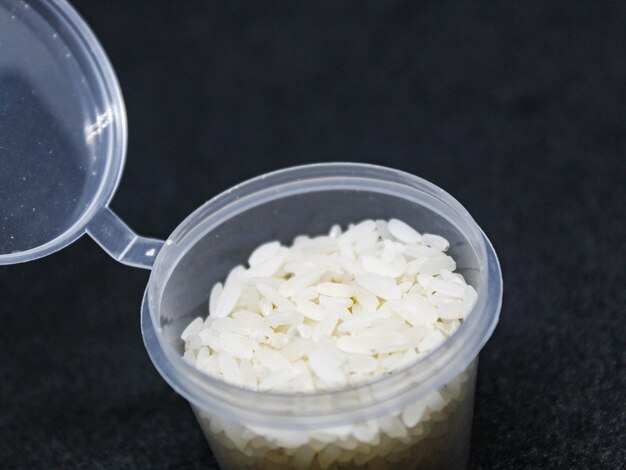 Rice in a small container isolated black background