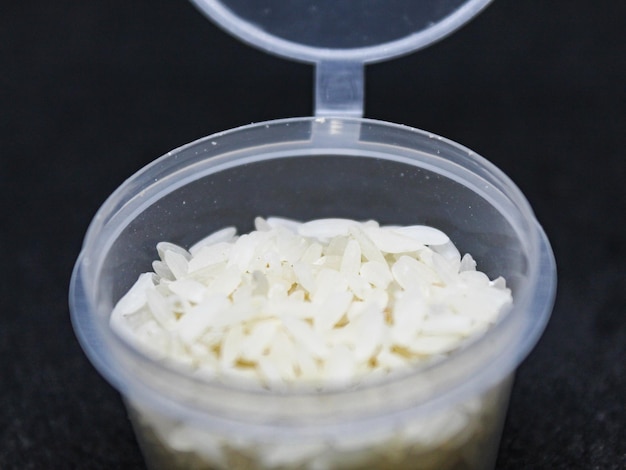 Rice in a small container isolated black background