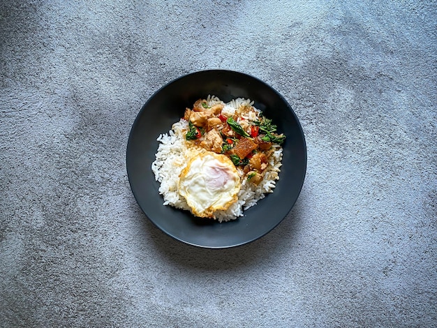 Photo rice topped with crispy pork belly with thai basil and fried egg