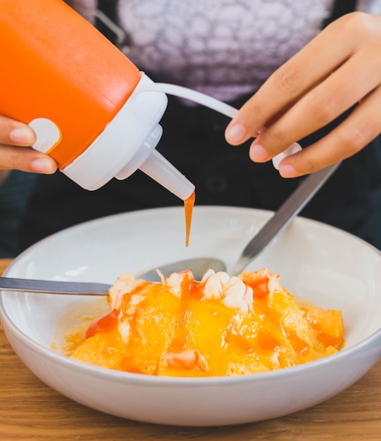 Foto riso condita con frittata con gamberetti e salsa di pomodoro sul tavolo di legno