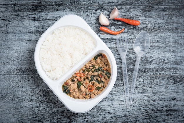 Rice topped with stir fried minced pork and basil on wood