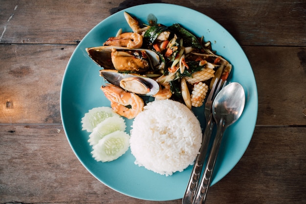 Rice topped with stir-fried mussels seafood and basil.