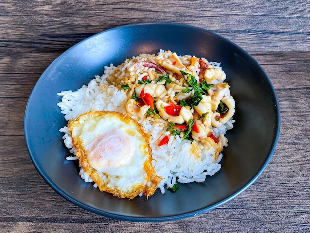 イカの炒め物と目玉焼きのバジルをトッピングしたご飯