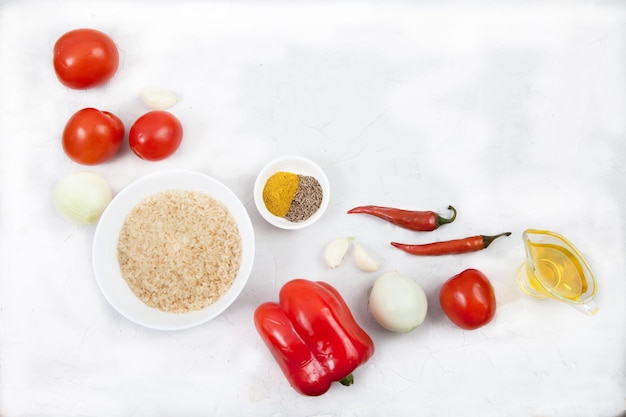 Rice vegetables and spices for cooking jollof rice on a white background Copy spaes