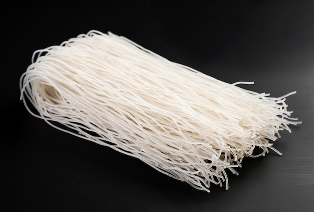 Rice vermicelli close-up on a black background. Funchoza