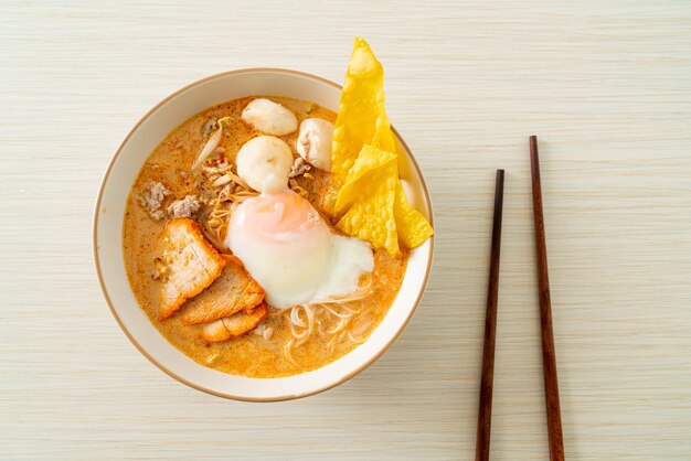 Rice vermicelli noodles with meatball, roasted pork and egg in spicy soup