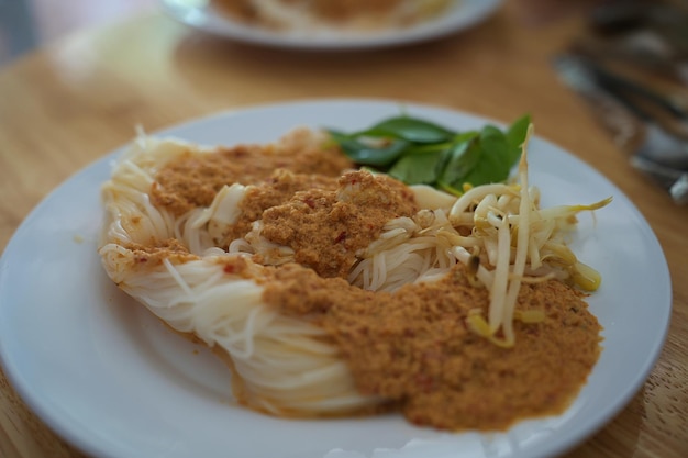 Foto vermicelli di riso con salsa al curry di pesce cibo tailandese da vicino a telaio intero