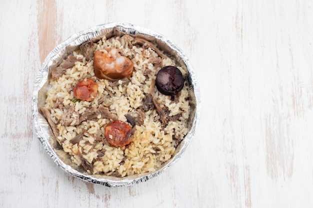 Rice with duck and smoked sausages in plastic box