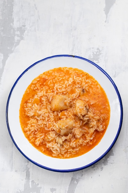 Rice with fish and tomato on dish