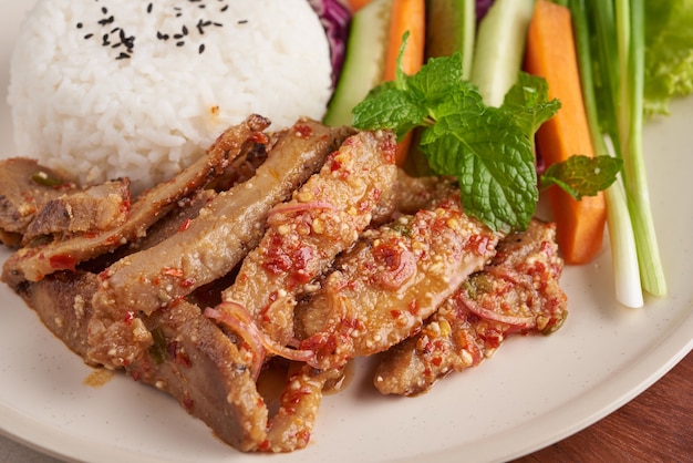 Rice with grilled pork neck. Grilled pork salad thai food with herbs and spices ingredients, tradition northeast food delicious with fresh vegetables, Hot and spicy slice grilled pork menu asian food.