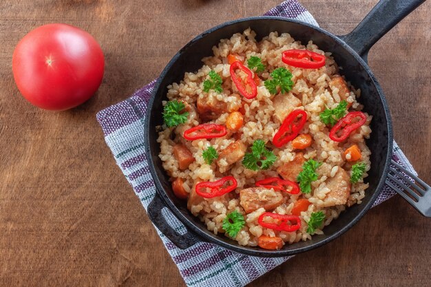 Рис с мясом, овощами и петрушкой на сковороде