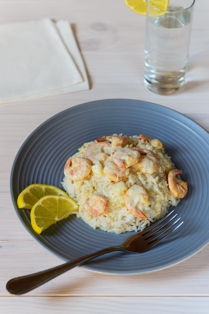 rice with prawns and lemon on a wooden table