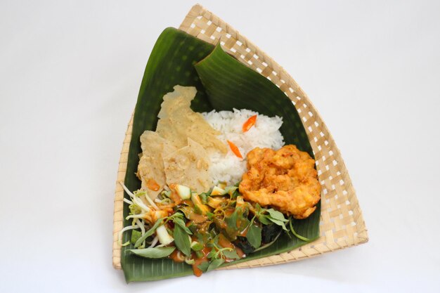 Rice with Shrimp and fried shrimp in a banana leaf basket on white background Pecel rice