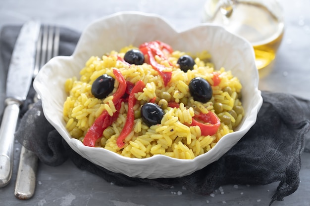 Rice with vegetables and black olives in beautiful dish