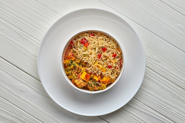 Rice with vegetables and cheese on a white plate