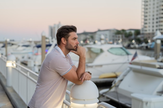 Rich businessman dreaming and thinking near the yacht portrait of confident man in modern big americ