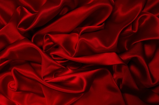 Rich and luxury red silk fabric texture background. Top view.