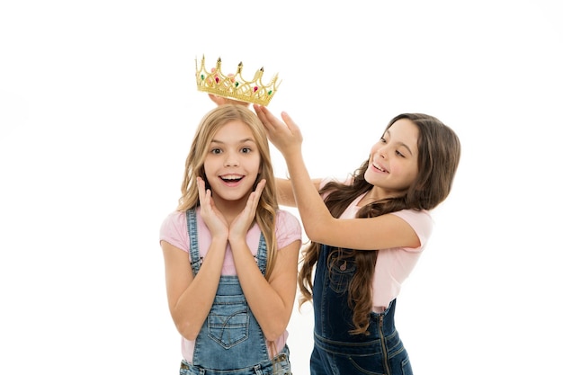 Rich reward. Little girl putting crown on head of small beauty queen winner as reward. Adorable mini miss beauty pageant winner taking reward for success. Awarding with prize and reward.