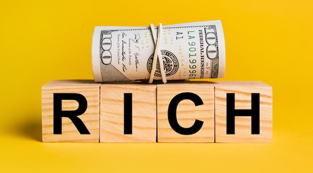 RICH with money on a yellow background. The concept of business, finance, credit, income, savings, investments, exchange, tax