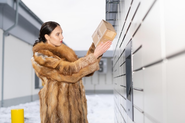 Photo the rich woman checks the senders address to see if she received the correct package receive and send parcels automatically in winter