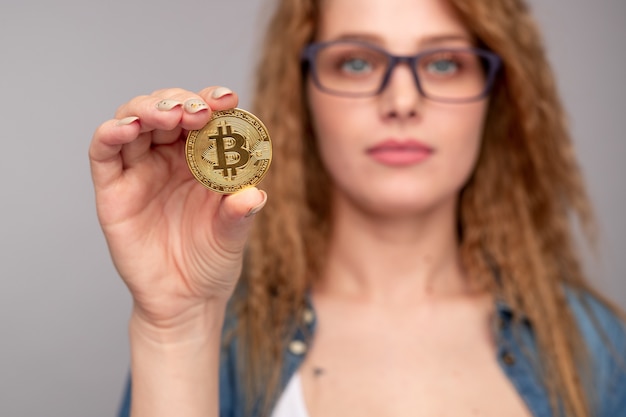 Rich young woman demonstrating bitcoin