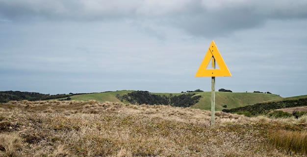 Richtingsbord op het veld tegen bewolkte lucht